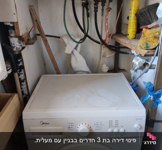 מכונת כביסה עם חומרי ניקוי ומברשת על מדף